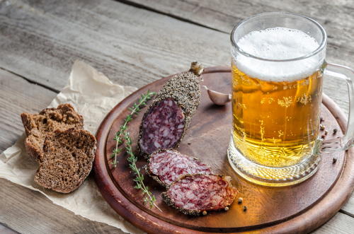 Slices of french Saucisson sausage with glass of beer